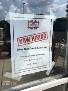Now Hiring sign posted on door