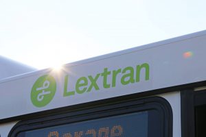 new year's: lextran logo in green on a white bus with the sun peaking over the top