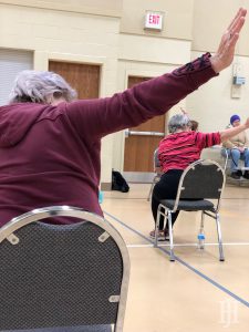 seniors performing chair yoga