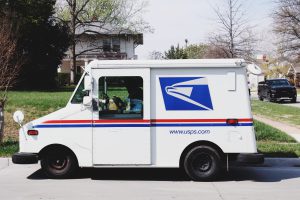 white mail truck in front of a residential house