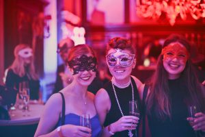 mardi gras: three women dressed up with masks