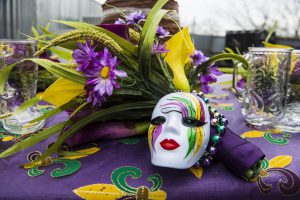 a mardi gras mask with purple, green, and yellow colors