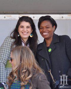 Parade: two women in jackets smiling at the camera