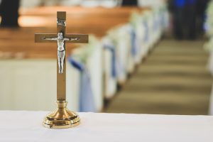 Easter Service: wooden cross on a table with a white cloth and pews