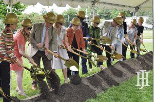 Senior: group of people in hard hats with shovels possing