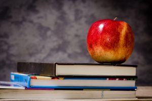 merit scholarship school Parents: blackboard with books on a desk and an apple