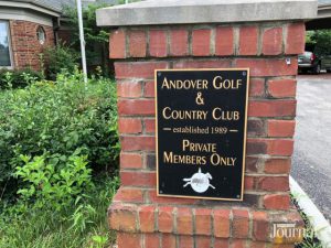 Neighborhood: plaque for a golf course on a brick wall