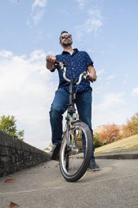 Lexington: a man on a bike with a blue sky behind him
