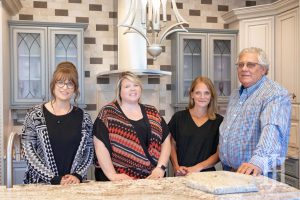 Hager Cabinets: four people around a kitchen island smiling at the camera