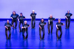 Senior Living: group of older women dancinc with canes and in black outfits