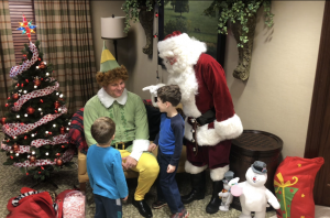 holiday guide Neighborhood: a man dressed as elf and santa claus with kids