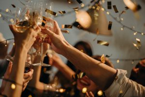 New Year's Eve: people clanking glasses with confetti